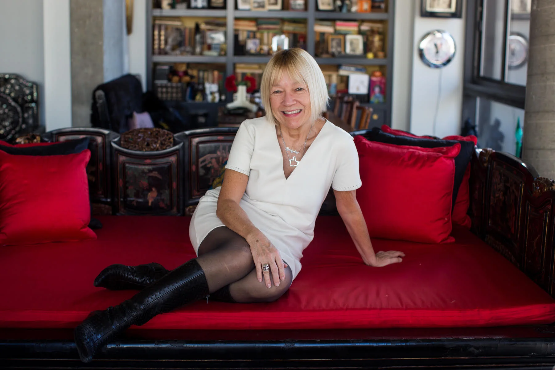Cindy Gallop in a white dress on a red sofa, photographed by Dorie Hagler.