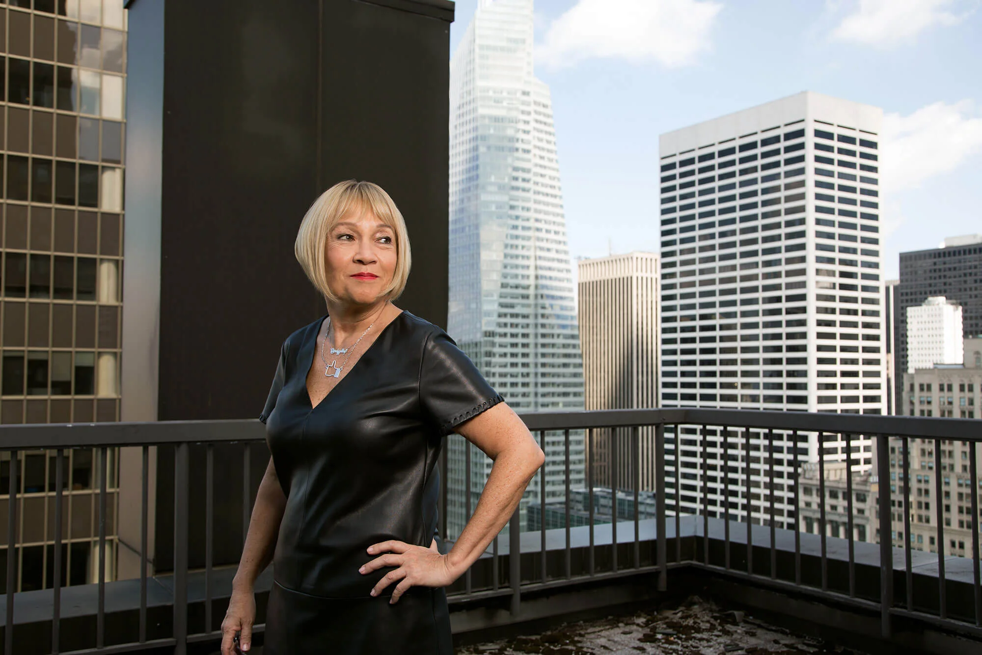 Cindy Gallop on a rooftop, hand on her hip, looking out over the Manhattan skyline.